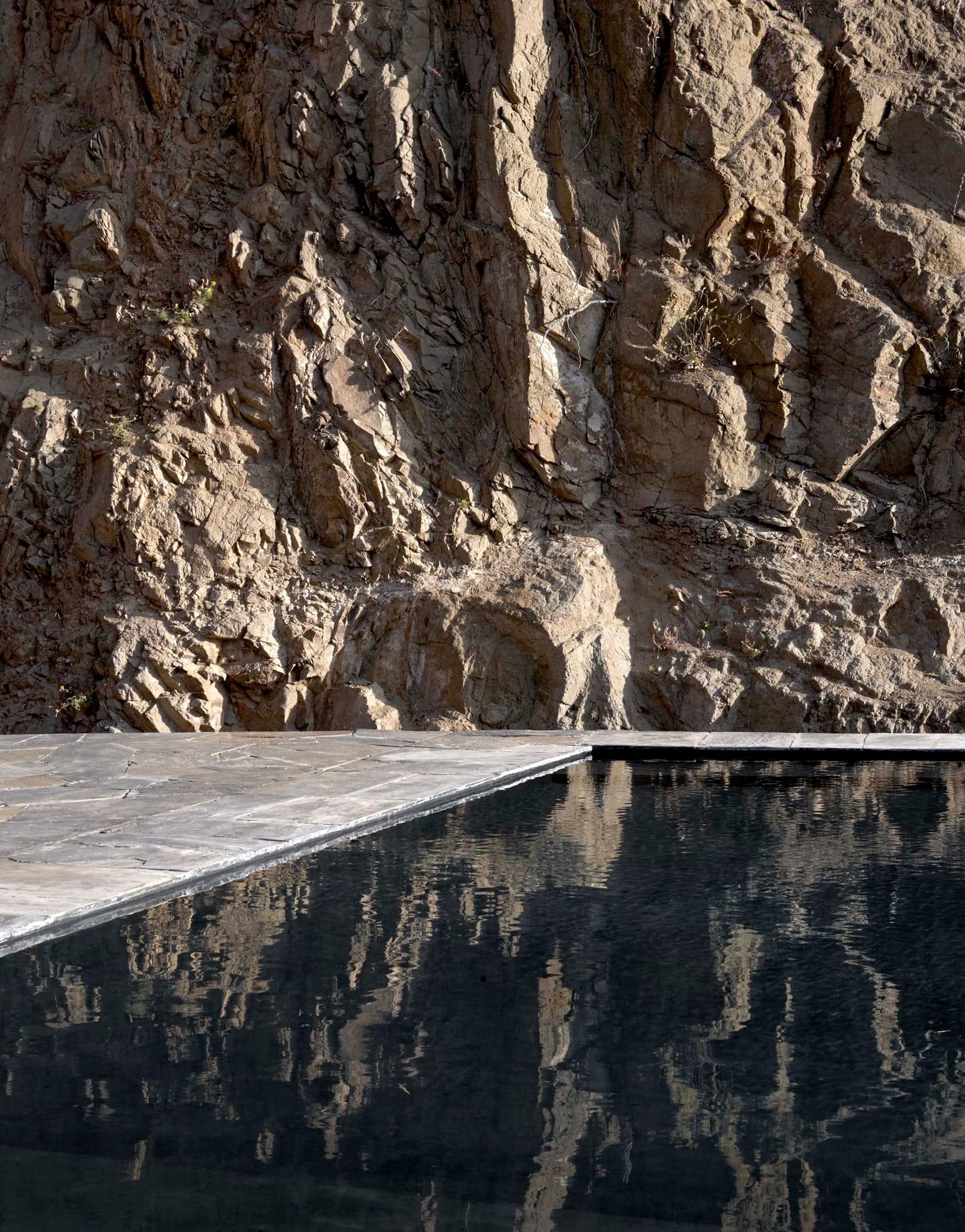 Black pool beneath a rock face, Villa E